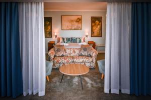 ein Hotelzimmer mit einem Bett und einem Sofa in der Unterkunft Die Badhuis, for Fabulous living! Sleeps 4, Private pool in Gordonʼs Bay