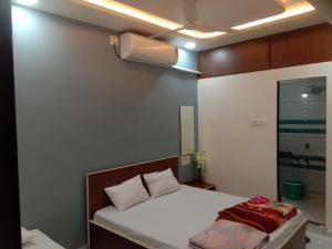a bedroom with a white bed and a fan at Aarambh Home stay in Garudeshwar