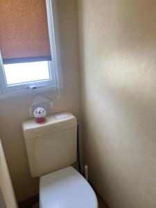 a small bathroom with a toilet with a window at Nice little house in Barcelona