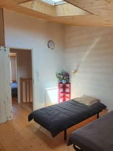 Un dormitorio con una cama y una mesa roja con flores en Le Chai Rit en Rivedoux-Plage