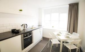 a kitchen with a table and a table and chairs at Fox Street Studios in Liverpool