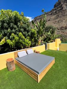 a bed on the grass with a mountain in the background at SUNNY CARMELITO DELUXE in Mogán