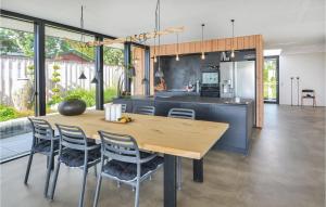 エーベルトフトにあるNice Home In Ebeltoft With 3 Bedrooms And Wifiのキッチン、ダイニングルーム(木製のテーブルと椅子付)