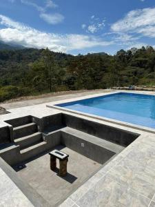 una piscina con escaleras y una mesa al lado en Cabaña en Guayabal de Siquima en Guayabal de Síquima