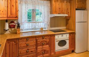 a kitchen with wooden cabinets and a white refrigerator at Cozy Home In stby With House A Panoramic View in Trysil