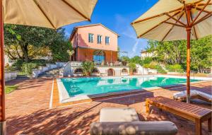a swimming pool with an umbrella and a house at Pet Friendly Home In Fucecchio With Wi-fi in Fucecchio