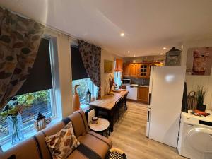 a kitchen and living room with a couch and a refrigerator at Downtown Historical House with Renovated apartments in Ålesund