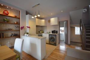 cocina con armarios blancos y fogones en Cheerful 2 bed home with terrace in central Camden, en Londres