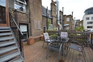 une terrasse avec une table et des chaises dans un bâtiment dans l'établissement Cheerful 2 bed home with terrace in central Camden, à Londres