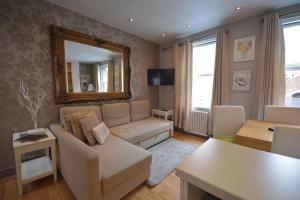 a living room with a couch and a mirror at Cheerful 2 bed home with terrace in central Camden in London