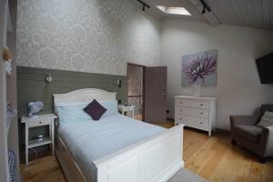 ロンドンにあるCheerful 2 bed home with terrace in central Camdenのベッドルーム(白いベッド1台、椅子付)