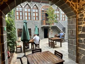 Dos personas sentadas en mesas en un patio al aire libre en Karga Butik Otel en Diyarbakır
