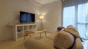uma sala de estar com um sofá e uma televisão em Apartamento en Miño em La Coruña