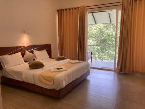 a bedroom with a large bed and a sliding glass door at Spice Forest Plantation Homestay, Thekkady in Vandiperiyār