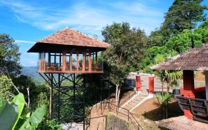 a tree house in the middle of a garden at Spice Forest Plantation Homestay, Thekkady in Vandiperiyār