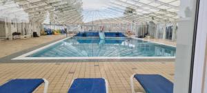 a large swimming pool with blue chairs in a building at Dog Friendly Caravan Heacham Norfolk Holiday in Heacham