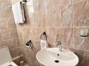 a bathroom with a sink and a toilet and towels at Exquisite two bedroom Penthouse-Fully Furnished in Kitale