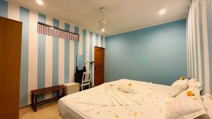 a bedroom with a bed and a blue wall at Midsummer Thulusdhoo in Thulusdhoo