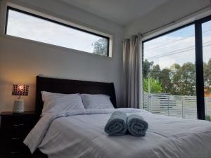 ein Schlafzimmer mit einem Bett mit zwei Handtüchern darauf in der Unterkunft Rosie Townhouse in prime location close to CBD in Melbourne