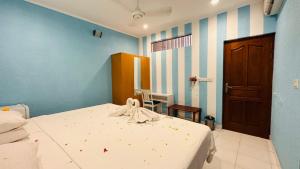 a bedroom with a bed and a blue wall at Midsummer Thulusdhoo in Thulusdhoo
