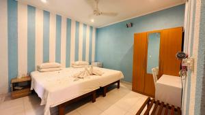 a bedroom with a bed and a blue and white striped wall at Midsummer Thulusdhoo in Thulusdhoo