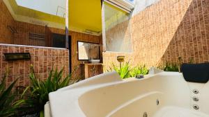 a bathroom with a white tub and a mirror at Midsummer Thulusdhoo in Thulusdhoo