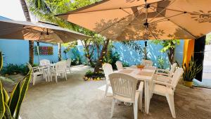 a restaurant with white chairs and tables and umbrellas at Midsummer Thulusdhoo in Thulusdhoo