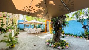 a patio with tables and umbrellas and plants at Midsummer Thulusdhoo in Thulusdhoo