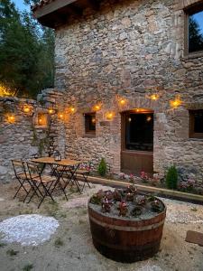ein Steingebäude mit einem Tisch und Stühlen im Hof in der Unterkunft Turisme Rural Ca l'Axai casa 2 in Pi