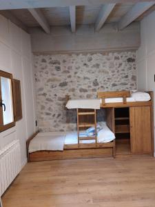 a room with two bunk beds and a stone wall at Turisme Rural Ca l'Axai casa 2 in Pi +8 photos