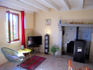 sala de estar con TV y chimenea en Property in Saint-Julien-La-Genête, en Saint-Julien-la-Genète