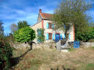 a house with blue windows and a stone wall at Holiday home in Saint-Julien-La-Genête in Saint-Julien-la-Genète