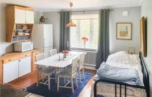 VimmerbyにあるNice Home In Vimmerby With 4 Bedrooms And Saunaのキッチン、ダイニングルーム(テーブル、椅子付)