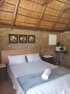 a bedroom with a large white bed in a room at Pepe Piatto Lodge in Grootvlei