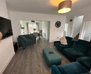 un soggiorno con divano verde e sedia di Roomy 3 BR bungalow in Sale, with Parking MCR a Broadheath