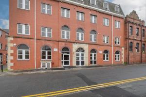 an empty street in front of a brick building at Thornhill House Serviced Apartments in Wakefield