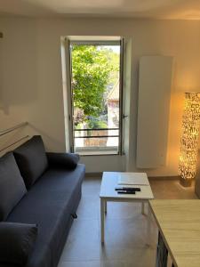 sala de estar con sofá, mesa y ventana en Maison au pied du château + parking privé en Champeix