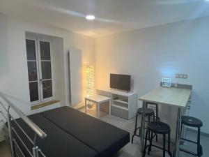 ein Schlafzimmer mit einem Bett und einem Schreibtisch mit einem Fernseher in der Unterkunft Maison au pied du château + parking privé in Champeix