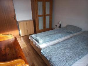 - une chambre avec 2 lits et un fauteuil en bois dans l'établissement hoteliving Düsseldorf Airport, à Ratingen
