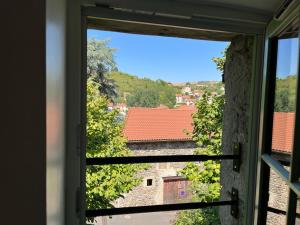 une fenêtre ouverte avec vue sur la montagne dans l'établissement Maison au pied du château + parking privé, à Champeix