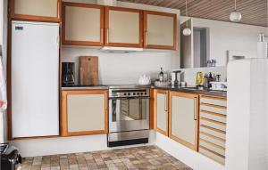 ニュボーにあるAmazing Home In Nyborg With 3 Bedrooms And Wifiのキッチン(木製キャビネット、ステンレス製オーブン付)