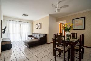 ein Wohnzimmer mit einem Sofa und einem Tisch in der Unterkunft Amplo apto 7 min do mar na Meia Praia EIO203 in Itapema