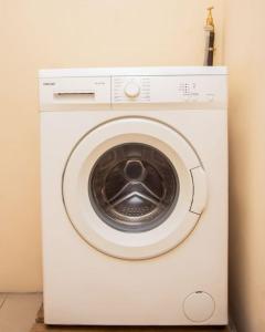 a white washing machine sitting in a room at Magnifique Appartement - Cotonou - Avotrou Apkapka in Cotonou