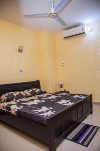 Łóżko w pokoju z wentylatorem sufitowym w obiekcie Magnifique Appartement - Cotonou - Avotrou Apkapka w mieście Kotonu