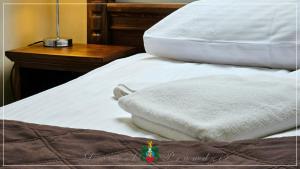 uma cama com duas almofadas brancas em cima em Dworek Prawdzic Niechorze em Niechorze
