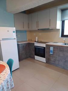 a kitchen with white appliances and a table in it at Studio 2 in Ayia anna