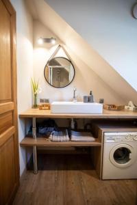 a bathroom with a sink and a washing machine at La grange du hameau in Saint-Lary-Soulan