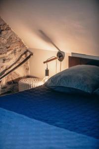 a bedroom with a bed with a blue blanket and a lamp at La grange du hameau in Saint-Lary-Soulan