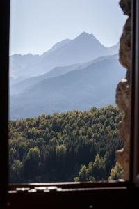 a view out of a window of a forest at La grange du hameau in Saint-Lary-Soulan