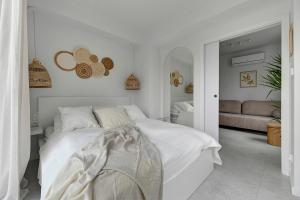 a white bedroom with a bed and a couch at Morze Apartamenty by Grand Apartments in Gdynia
